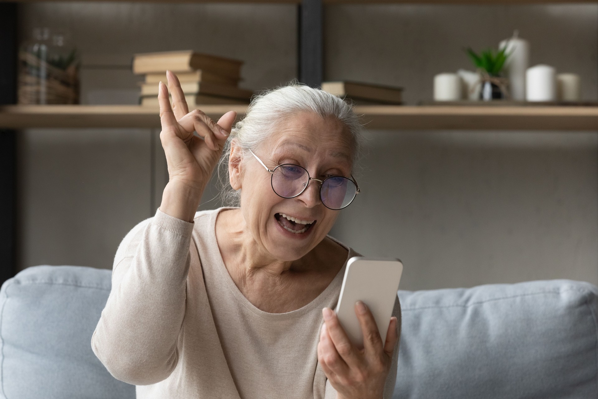 Excited freaky grandma talking on video call to grandchildren