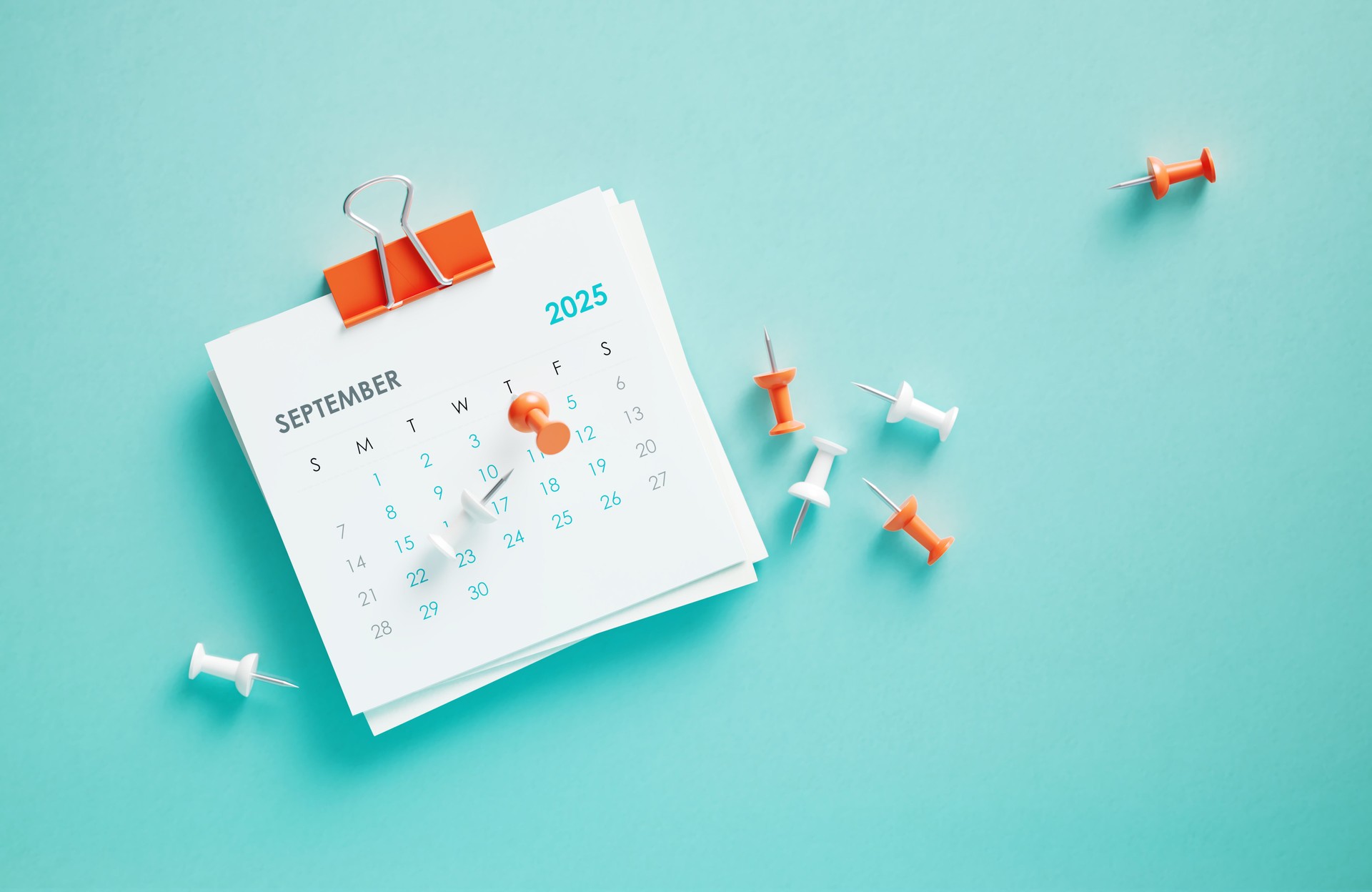 September 2025 Calendar And Thumbtacks On Blue Background